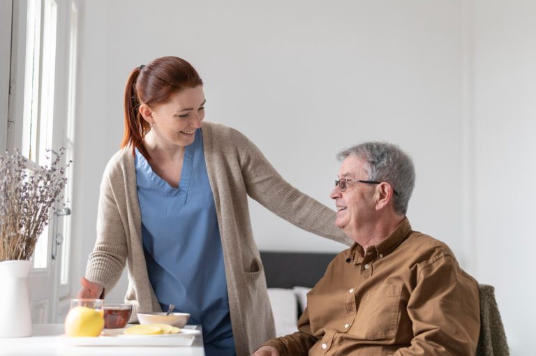 nurse talking to older man in brown shirt